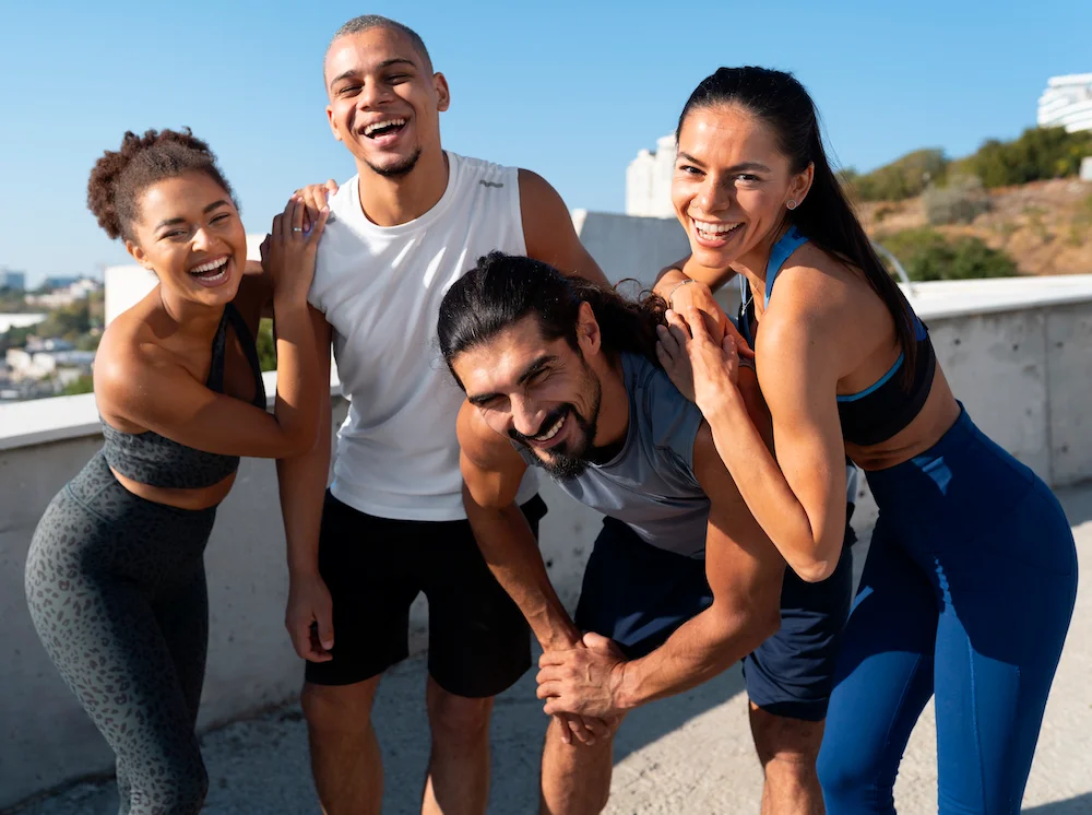 Deux hommes et deux femmes en tenue de sport qui rigole